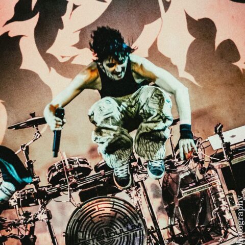 Drummer leaping off the kit